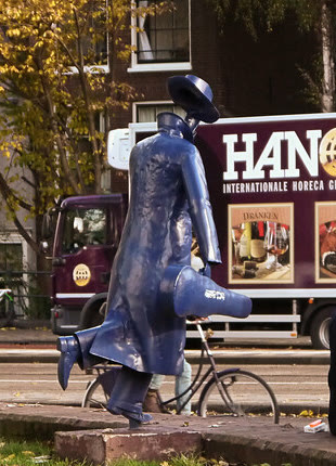 Blaue Statue eines Mannes mit Hut und Mantel